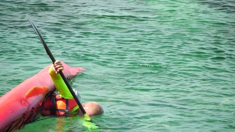 Man trains in kayak eskimo roll, slow motion. Kayak on turquoise sea water Stock Footage 249658564