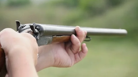 Man trains skeet shooting, while aiming from his shotgun outdoors in slo-mo Stock Footage