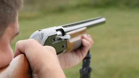 Man trains skeet shooting, while aiming somewhere from his shotgun outdoors Stock-Footage 76054426