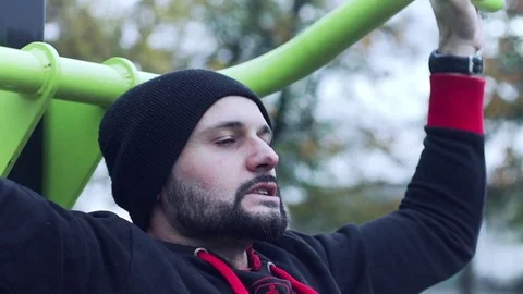 Man trains strenuously lat pull downs in a park Vídeo Stock 70520919