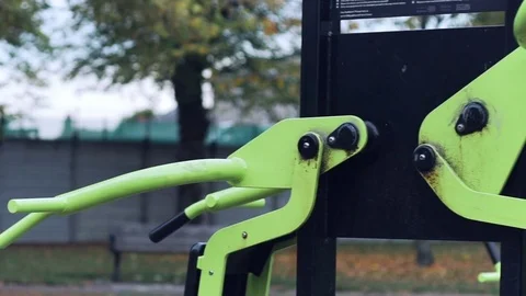 Man trains strenuously lat pull downs in a park, pan Vídeo Stock 70522653