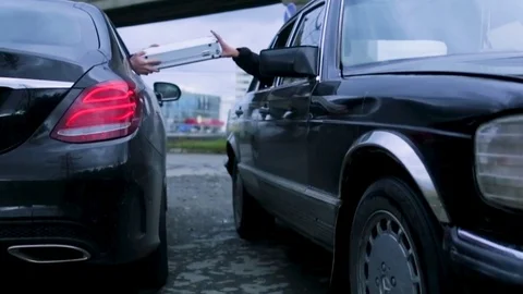 Man transfer metal case or briefcase to another man through a car window Stock Footage 85252588
