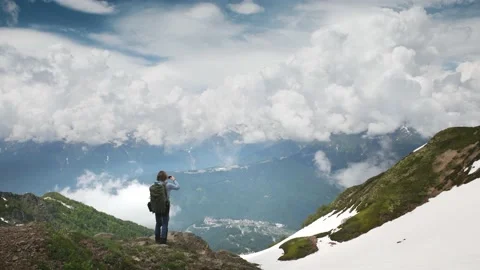 Man traveler with backpack standing on the top of the mountain Stock Footage 234068623
