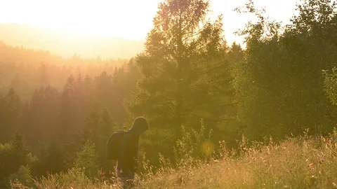 A man traveler with a backpack at sunset goes up the mountain. Stock Footage 112228717
