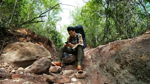 Man traveler with backpack using smartphone in the natural forest Video stock 128207622