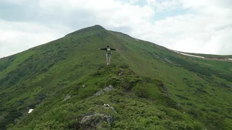 Man traveler experiences emotions while on top of a mountain Stock Footage 160770853