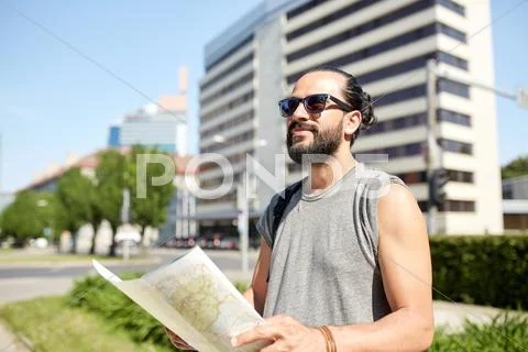 Man traveling with backpack and map in city Stock Photos