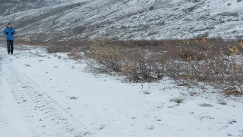 A man travels in the mountains. He goes on a snowy road. Video stock 97597553