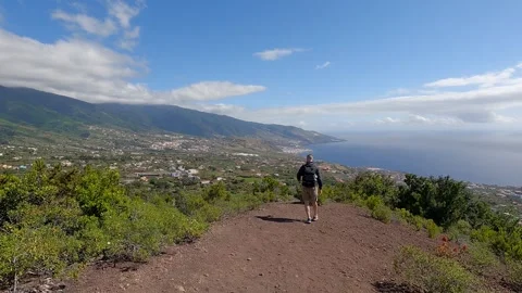 Man trekking along a path with sea views Stock Footage 266800656