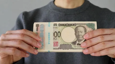 A man with trembling hands taking out a stack of bills from his pay envelope Video stock 324548892