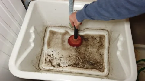 Man tries to break through the clogged sink in the bathroom using a plunger Video stock 132071996