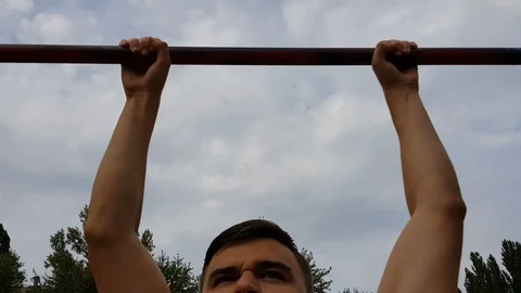 Man tries to complete pull up with funny comedic face and succedes, try hard Stock Footage 94907743
