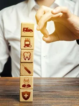 A man tries to knock down a tower of blocks with attributes of medicine sym.. Stock Photos