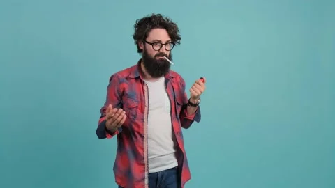 Man tries to light a cigarette and returns with a surprised look to the camera. Stock Footage 146234724