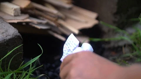 A man tries to light a fire with paper Stock Footage 114630823