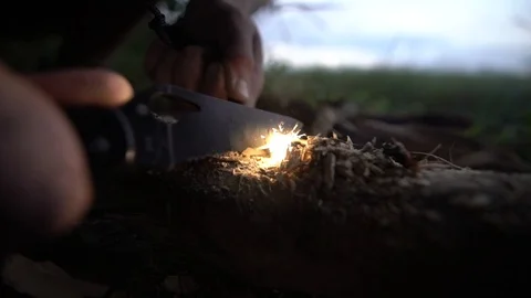 Man tries to make fire with flint and firewood Stock Footage 129105300