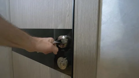 A man tries to open a door in a room that is locked. He pulls the doorknob Stock Footage 336466319
