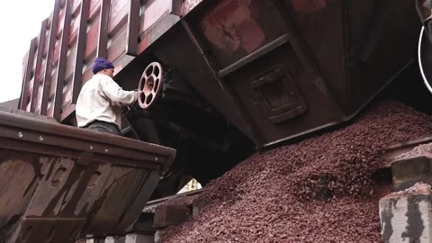 Man tries to open a hatch (door) to unload rubble from the train. Stock Footage 196087475