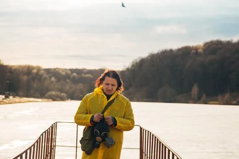A man tries to remove the mask on the background of the natural landscape with Stock Photos