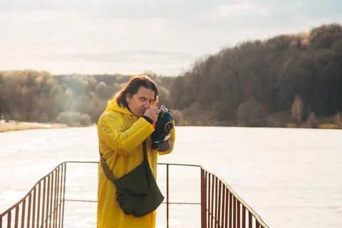 A man tries to remove the mask on the background of the natural landscape with Stock Photos