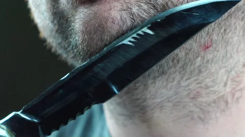 A man tries to shave his beard hunting knife Stock Footage 130222216