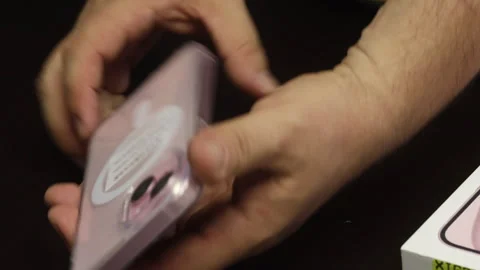 The man tries on a silicone cover on an iPhone 15. Makes the unpacking of t.. Stock Footage 277546241