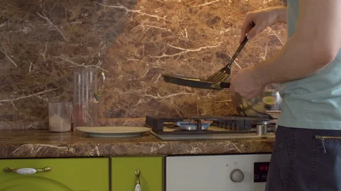 Man tries to turn over a fried pancake Stock Footage 128920207