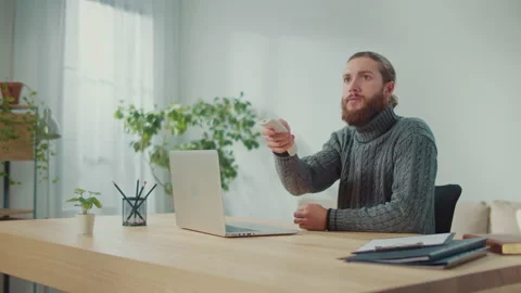 Man Tries to Warm Up in Warm Clothes While Working Online in Cold Room. Stock-Footage 222463709