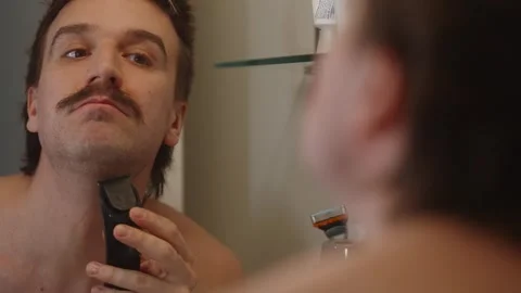 Man trimming beard into Moustache in mirror (4k60p) 库存影片 335015968