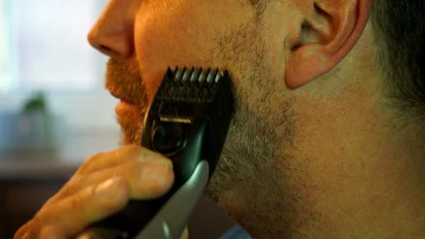 Man trimming his beard with an electric trimmer Video stock 88239643