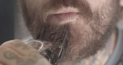 Man trims beard with electric clippers. Video stock 134661895