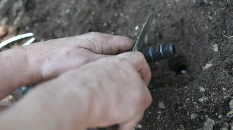 Man trims sprinkler connection Stock Footage 41436008