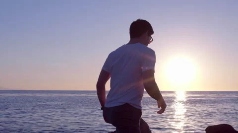 Man Trips On A Rocks, Trying To Get Closer To Water To Watch The Sunset Video stock 47292869