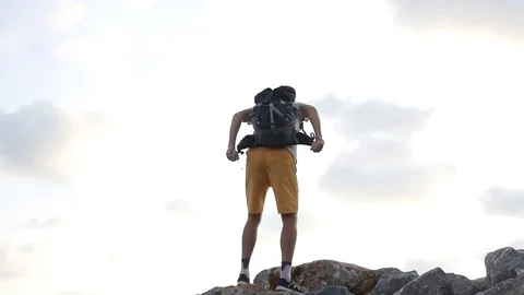 A man with a trouser behind his back feels freedom on the top of the mountain Video stock 93707095