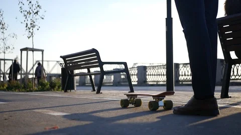 A man in trousers and a jacket in the fall on a skateboard straightens his arms Video stock 109086440