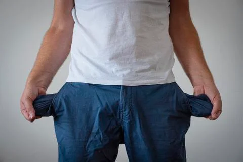 A man in trousers with empty pockets turned out. Stock Photos