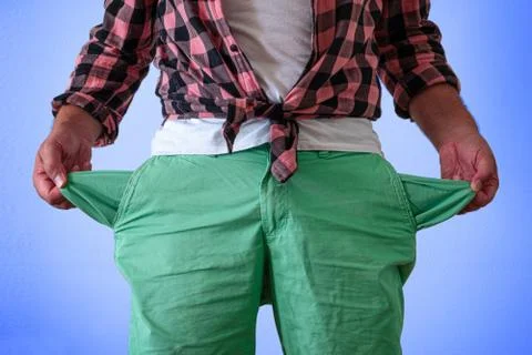 A man in trousers with empty pockets turned out. Stock Photos