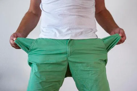 A man in trousers with empty pockets turned out. Stock Photos