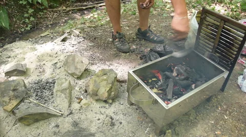 Man try to fire coal in barbecue with manual fan at forest Stock Footage 66255777