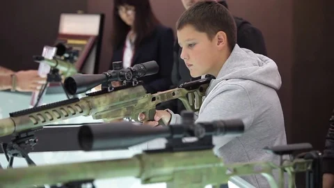 Man trying and exploring gun with rifle scope in the military shop Stock Footage 69734153