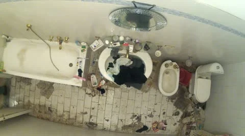 Man trying to clean up messy dirty bathroom Stock Footage 21234039