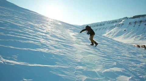 A man trying to climb the mountain on a slippery frozen snow, slips and falls. Stock Footage 55069313