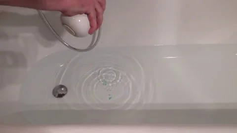 Man trying to create foam in a bathtub, bubble bath, bath foam, shower hea Stock Footage 76804864