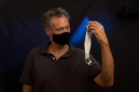 Man trying to decided what protective mask to wear Stock Photos