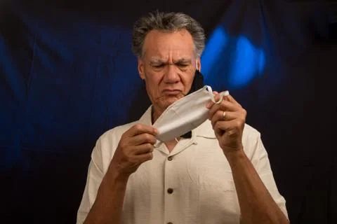 Man trying to decided what protective mask to wear Stock Photos