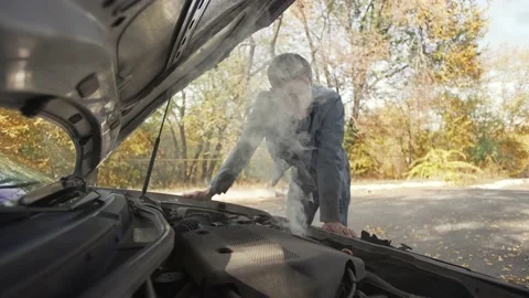 Man in trying to fix a damaged car Stock Footage 163457436