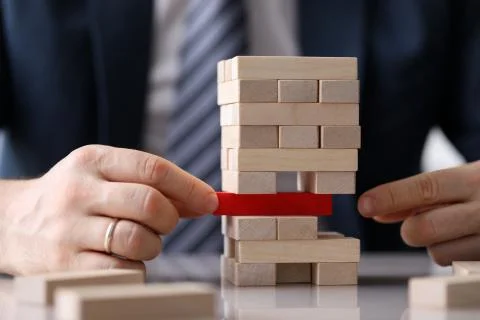 Man is trying to hold structure made wooden blocks Stock Photos