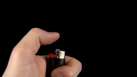 A man is trying to light a lighter. A man holds a lighter in his hand and spins Stock Footage 123313107