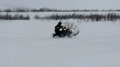 Man is trying to perform a trick on a snowmobile Stock-Footage 102212310