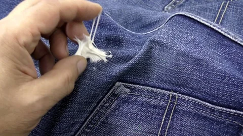 Man is trying to remove chewing gum adhering to jeans. Video stock 118793351